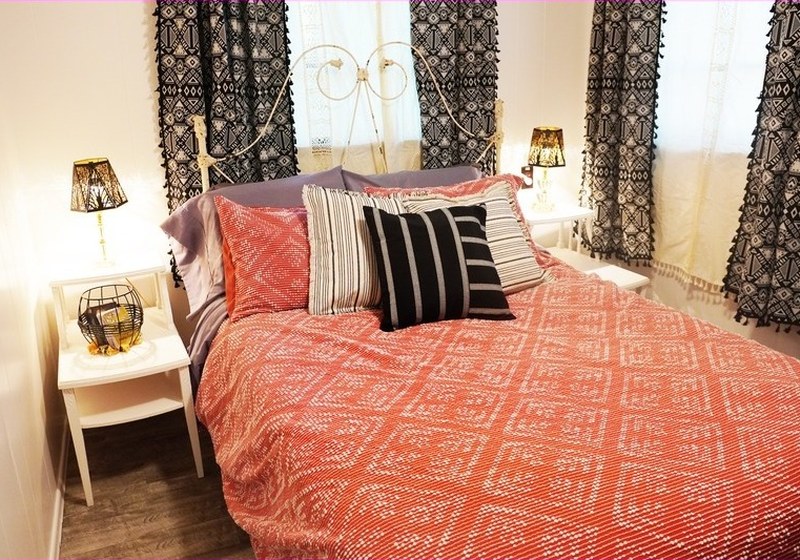 The second bedroom, with a coral bedspread and lace curtains