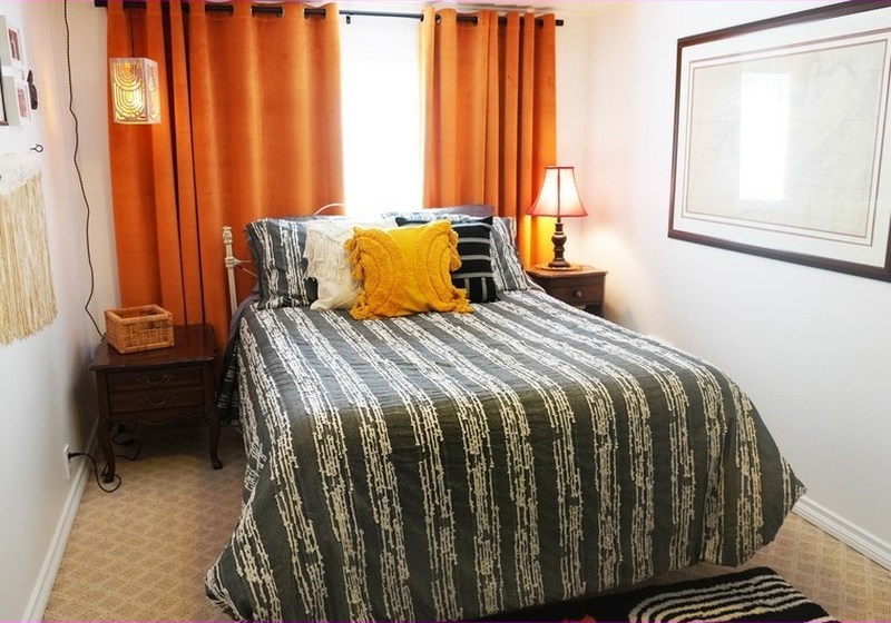 The main bedroom, with orange curtains and striped bedding