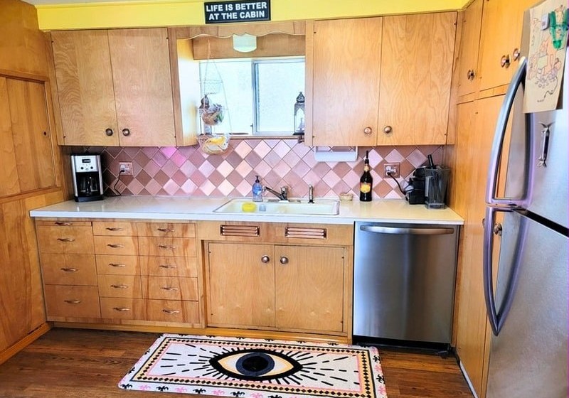 Kitchen with pine cabinets and a pink tiled backsplash